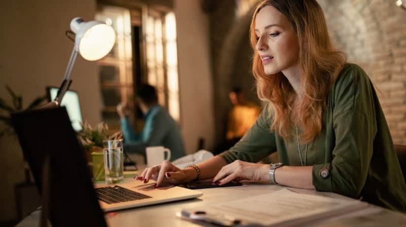 Woman writing on a laptop in a modern office; cover for a search-intent SEO content guide